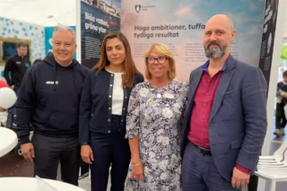 Fyra människor vid ett stånd på en mässa