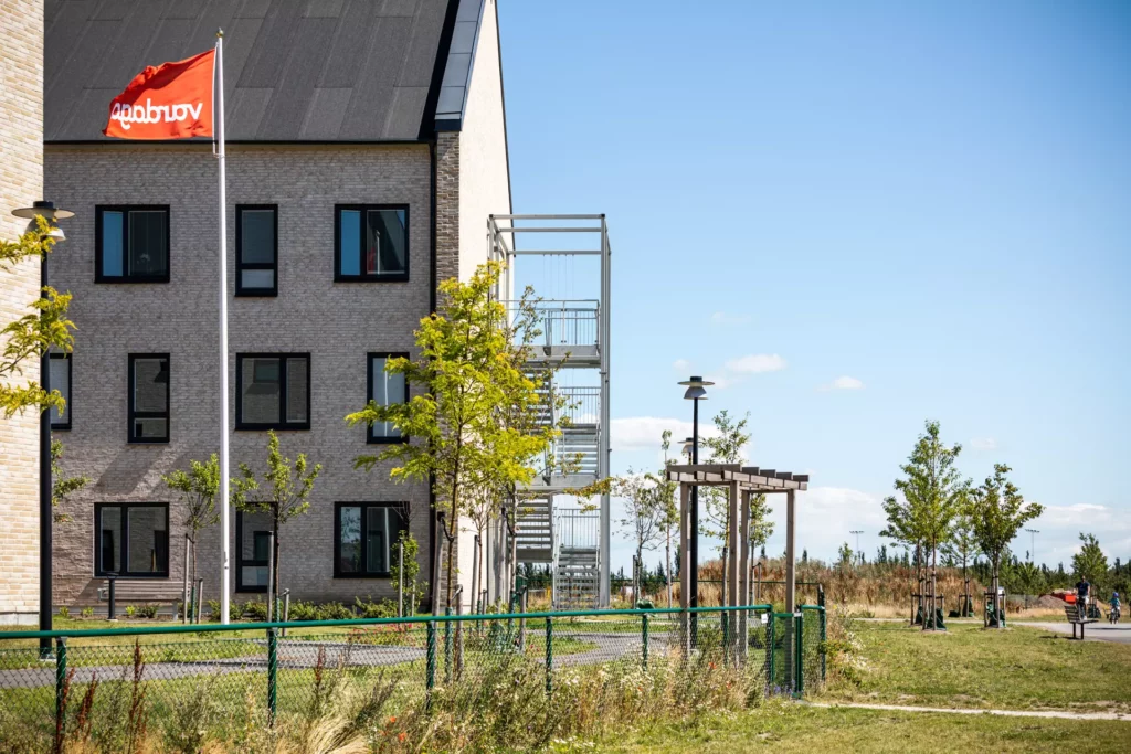 Äldreboendet Vlla vikhem i Staffanstorp har ljus tegelfasad och mörka foder runt fönstren. Bygnaden är tre våningar hög. Nyplanterade träd omger huset.
