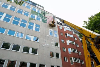Skylift med person som målar husfasad