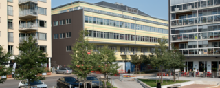 En byggnad i 7o-talsstil med många fönster. Under fönstren är fasaden gul.