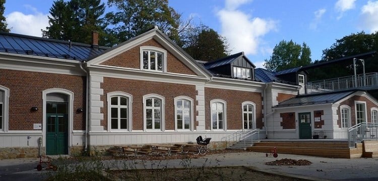 En äldre tegelbyggnad med stora, välvda fönster.