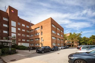Tegelbyggnad med parkering framför