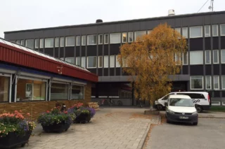 Flervåningsbyggnad med parkering utanför
