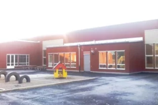 Röd byggnad med lekplats