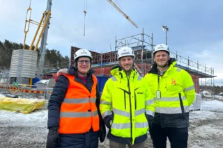 Birgitta Abdersson, projektledare samhällsbyggnad, Tobias Lagerwall, projektchef Hemsö och Simon Hagman, projektchef k21 framför den påbörjade byggnationen av Forshälla Strands förskola i Ljungskile.