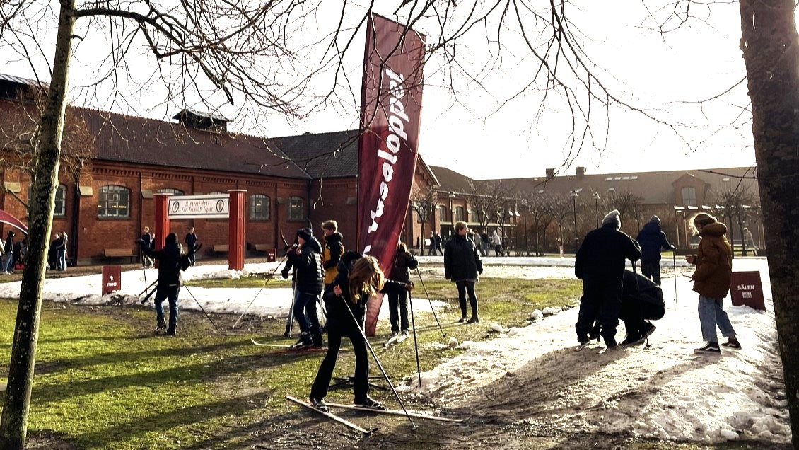 En pojke åker skidor. I bakgrunden syns Ystads regementsbyggnader.