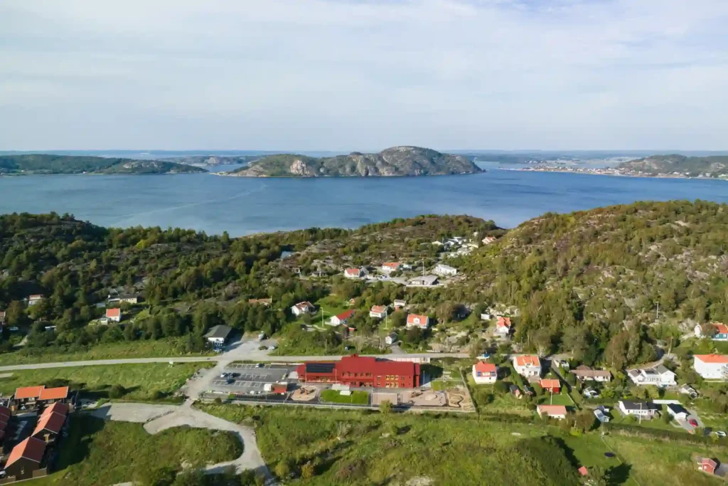 Förskolan i Tjuvkil är en röd byggnad på två våningar som ligger nära havet.