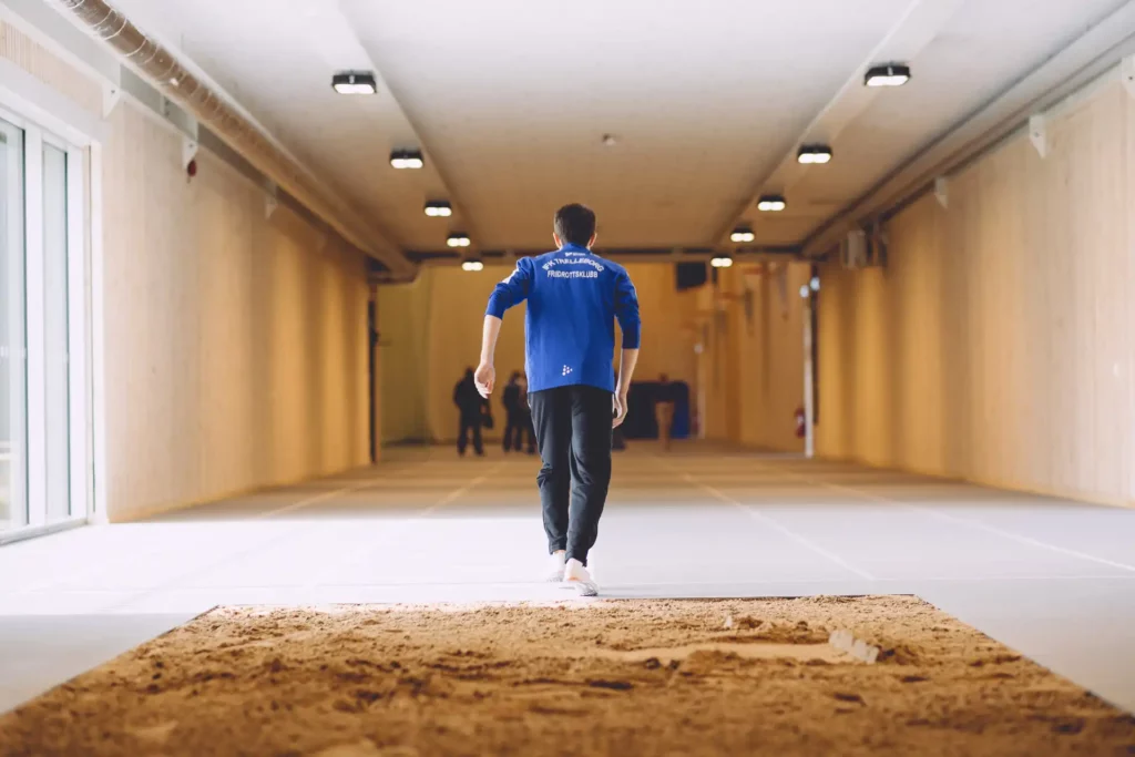 Pilehallen, idrottsanläggning i Trelleborg, här kan friidrott utövas året runt, på bilden visas en idrottare och i förgrunden en yta med sand för längdhopp och tresteg.